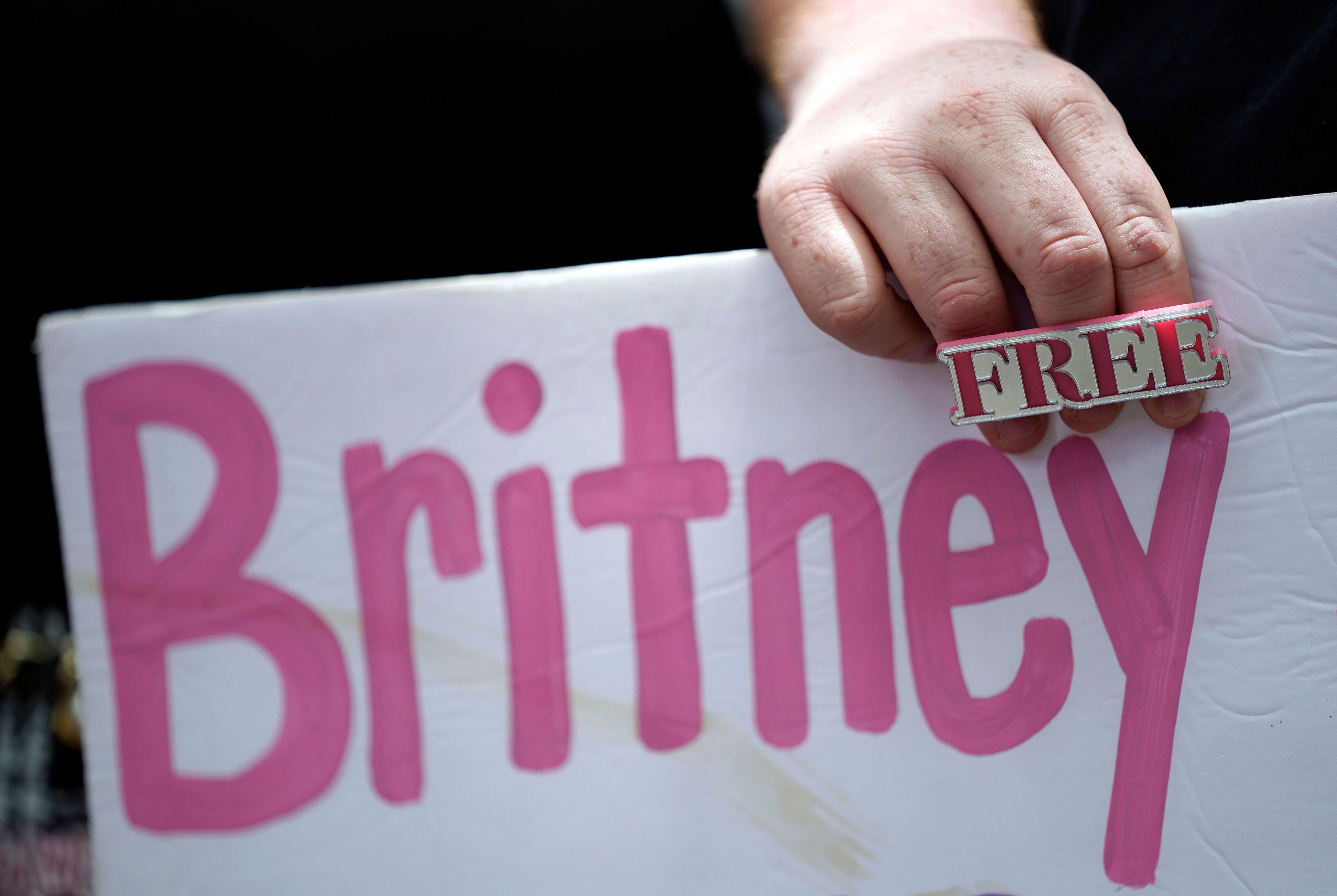 Un simpatizante de Britney Spears sostiene una pancarta afuera de una corte durante una audiencia sobre la curaduría que controla la vida y finanzas de la estrella pop, el miércoles 23 de junio de 2021 en Los Ángeles. (AP Foto/Chris Pizzello)